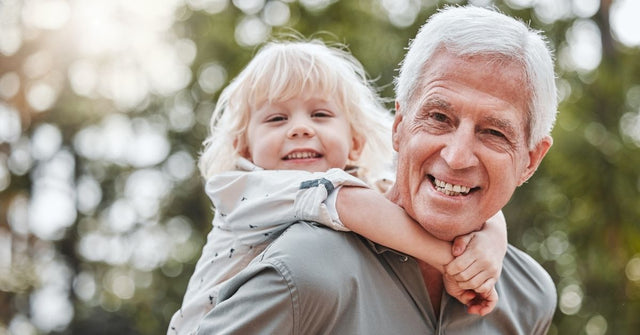 Vitamin-B12-Tagesbedarf in jeder Lebensphase – aktiver Senior mit Kind im Freien